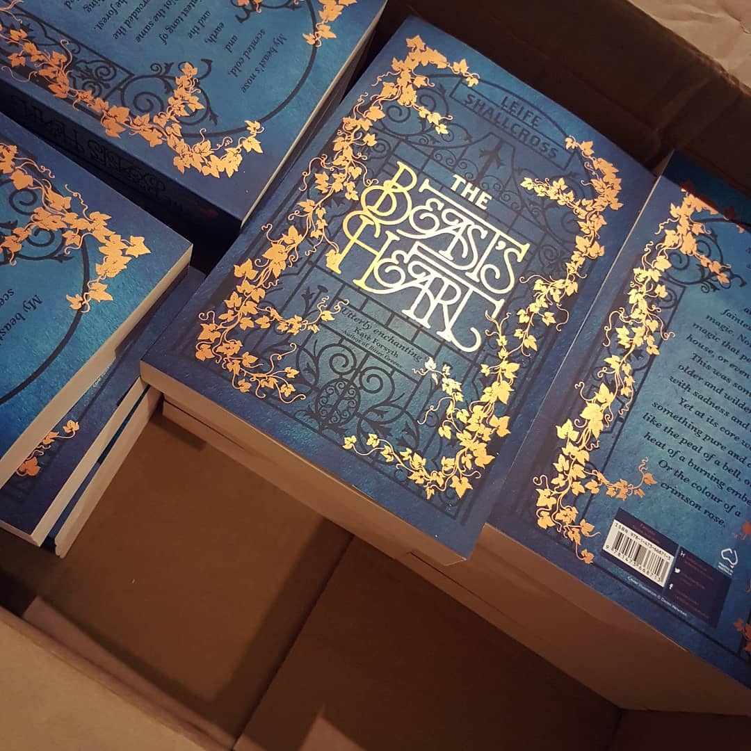 A box full of paperback books, titled The Beast's Heart. The cover is decorated with shiny coppery ivy.